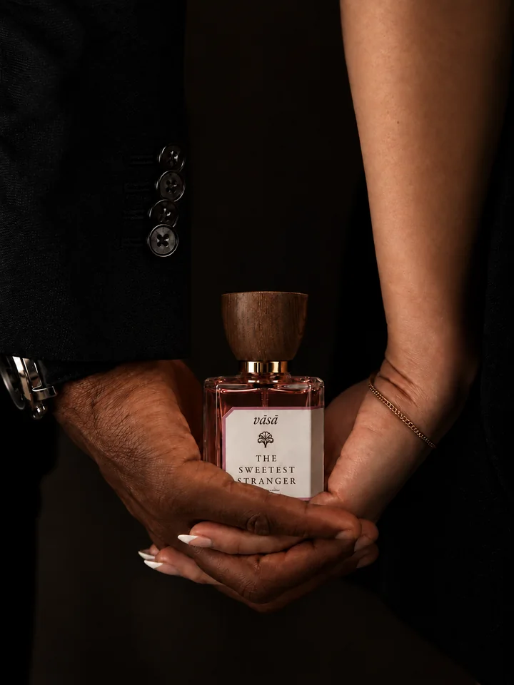 Two hands in a dark suit cradling The Sweetest Stranger